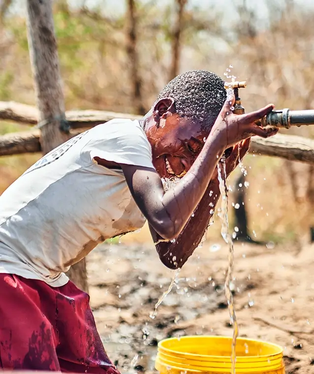 Zambian_boy_washing_at_communal_tap_Mafisa_T A young Zambian boy cooling off under a communal water tap. Mafisa.